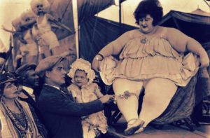Man with infant gawks the Sideshow Fat Woman